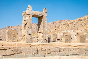 Persepolis, beautiful stone archway stands tall with a blue sky, Iran