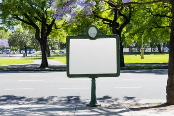 A historical blank billboard, on the street in Buenos Aires, Argentina, with jacaranda trees in the background during spring. Space for text for advertising signage ideas for mockup