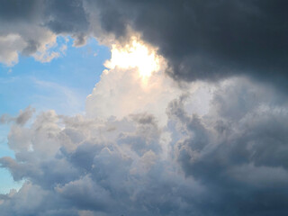 This captivating image showcases a breathtaking moment in nature as dark, brooding storm clouds dramatically part, revealing a burst of sunlight cutting through the sky
