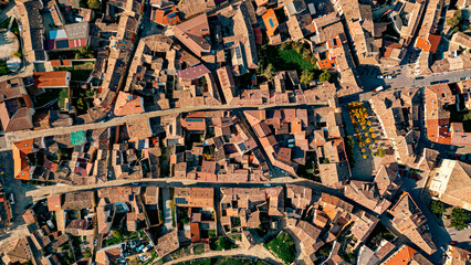 Obraz premium A detailed aerial shot of Astudillo, Spain, showing the intricate layout of rooftops, narrow streets, and charming medieval architecture from above.