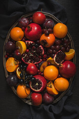 Fresh colorful fruits and berries  on a decorative rustic metal tray. Top view. Dark background.