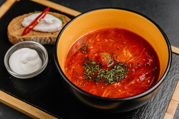 Spicy borscht soup with sour cream and rye bread, a traditional Eastern European comfort dish