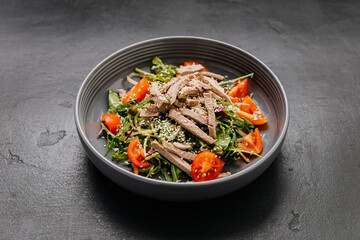 Fresh salad bowl with sliced beef, cherry tomatoes, and sesame seeds. Perfect healthy meal option