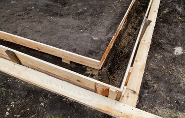 Obraz premium A wooden board is laying on the ground next to a dirt area