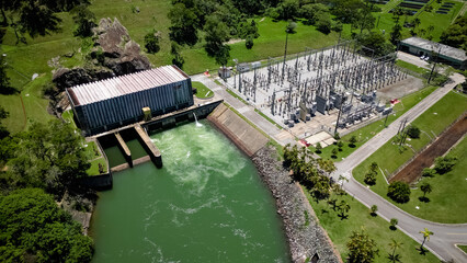 Usina Hidreletrica visto de cima com a natureza ao lado com ceu azul.