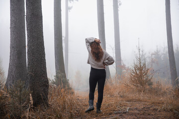 Sylwetka kobiety w lesie w porannej mgle © meegi