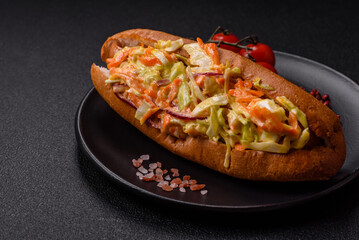 Hotdog with grilled sausage with cabbage, carrots and onions