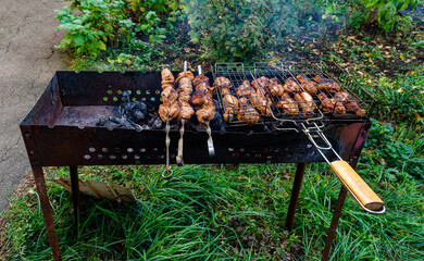 Man cooking meat on barbecue grill at bbq party in summer garden. Food, people and family time concept