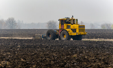The tractor plows the land in autumn, for sowing. Image of agriculture