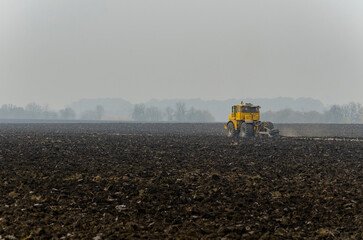 The tractor plows the land in autumn, for sowing. Image of agriculture