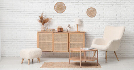 Modern chest of drawers with decor, armchair, coffee table and pouf in room