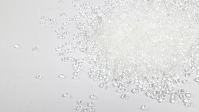 Virgin polycarbonate plastic granules are poured on a white background, one of the main materials in the plastics industry,perfect for catalog design and plastic industry company profiles