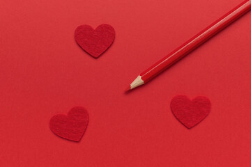 Red Pencil and Felt Hearts on Vibrant Background: Love and Creativity Theme in Modern Photography