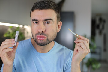 Man applying very shiny lip gloss