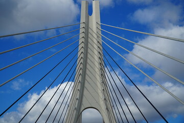 Naklejka premium New suspension bridge of the Arade river (Rio Arade), Portimao, Algarve, Portugal. Geometry of the white suspension cables for the N125 federal highway against the blue sky.