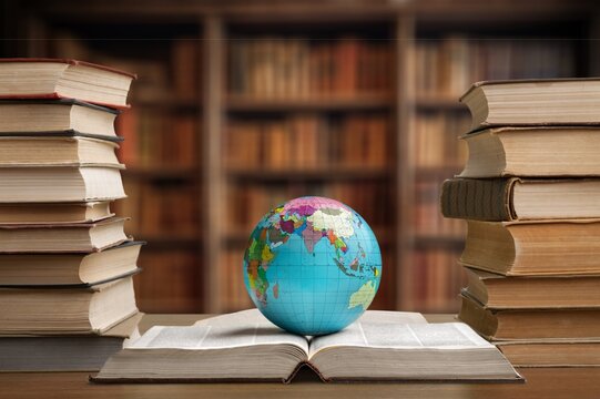 Old globe on open book on desk in a library.
