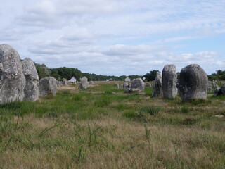 Rows of menhirs. The  meaning is unknown, but the cultic or calendaric significance in the Neolithic period. The historical unity is being disturbed by modern houses, in Carnac France
