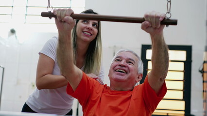 Fototapeta premium Female Pilates Coach helping senior man to use machine, old person training muscle in sport lifestyle 