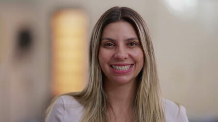 Happy woman spontaneous laugh and smile, close-up face of a female person in 30s looking at camera