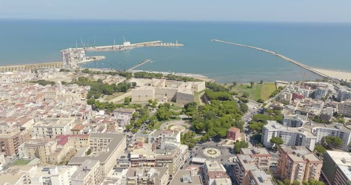 Aerial view of the castle located in Barletta, Puglia, Italy. It was a medieval fortress built on the coast of the Mediterranean Sea. Today it's a museum. In the background is the port of the town.