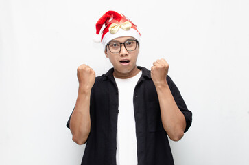 happily attractive young asian man wearing santa claus hat and christmas glasses dancing and celebrating christmas. christmas and holiday concept.