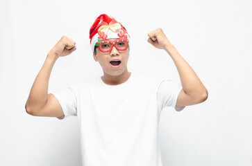 Naklejka premium happily attractive young asian man wearing santa claus hat and christmas glasses dancing and celebrating christmas. christmas and holiday concept.