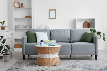 Interior of light living room with sofa and first aid kit on table