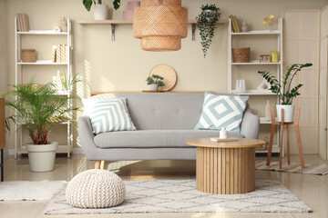Interior of living room with grey sofa, table and shelf units