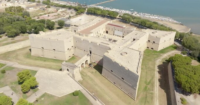 Aerial view of the castle located in Barletta, Puglia, Italy. It was a medieval fortress built for defense and today it is a museum. There is a park around the fort. In background is the Adriatic sea.