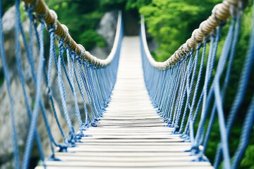 Obraz premium Close-up of a rustic rope suspension bridge stretching over lush greenery, symbolizing adventure and exploration. 