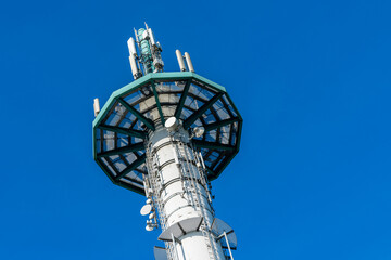 Telecommunications tower with antennas against a clear blue sky