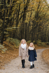 Fototapeta premium two girls with fair hair take a walk in the autumn park