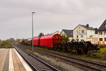 Fototapeta premium Train cars parked alongside residential buildings on a cloudy day