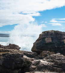 Atlantic Ocean waves whipping white foam against the rocky shore, Ericeira, Portugal.