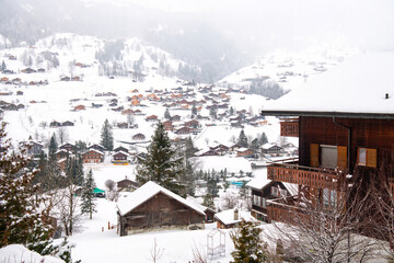 Grindelwald, under the soft glow of the night lights, transforms into a magical village where the snow glistens and each chalet seems to watch over the peaceful, slumbering mountains, Switzerland.