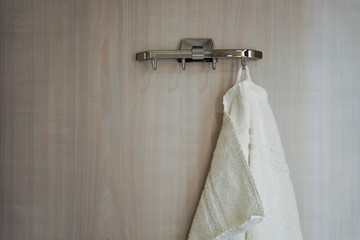 White hand towel on a hook on the bathroom door 