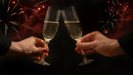 Toast with sparkling wine or champagne glasses on dark black night background - Young woman und man holding glass in the hand