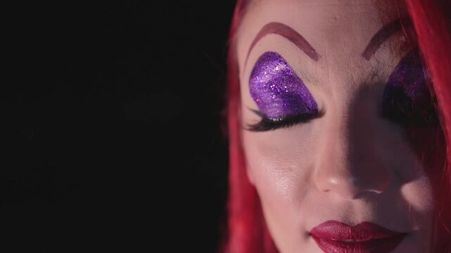 Close-up of Beautiful Redhead Woman with Artistic Character Makeup, Purple Glitter Eyelids and Red Lips. Primer Plano de Mujer Pelirroja Muy Hermosa con Maquillaje Art&iacute;stico de Caracterizaci&oacute;n,
