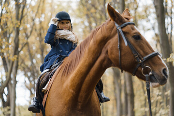 Obraz premium Young girl rides a horse in the forest.