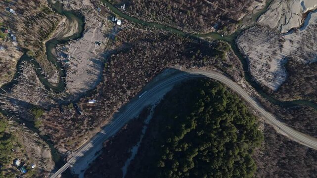 aerial shot captures Route 40 winding through the Patagonian landscape, near the Argentine-Chilean border. The Rinc&oacute;n Arm of Lake Nahuel Huapi is visible, surrounded by rugged terrain and dense forest