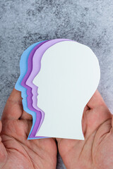 Male hands hold a silhouette of a human head with different shades of purple. Alzheimer's disease....