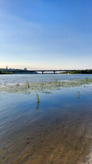 Calm River Scene with Bridge and Skyline in the Distance