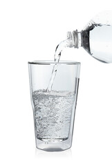 Pouring soda water from bottle into glass on white background