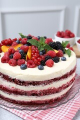 Tasty sponge cake with different fruits and mint on light grey table