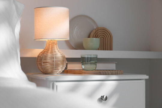 Stylish living room interior with bed, bedside table and lamp