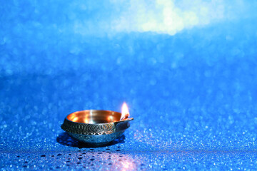 Diwali celebration. Diya lamp on blue background. Space for text