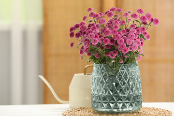 Beautiful pink flowers in vase on table at home