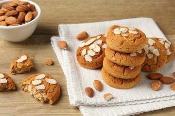 Tasty cookies with almond flakes and nuts on wooden table, closeup