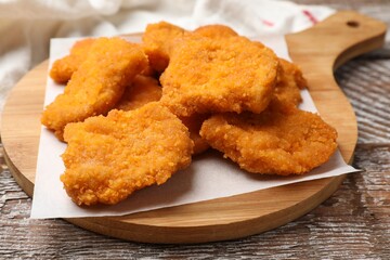 Delicious chicken nuggets on wooden table, closeup