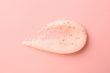 Smear of body scrub on light pink background, top view